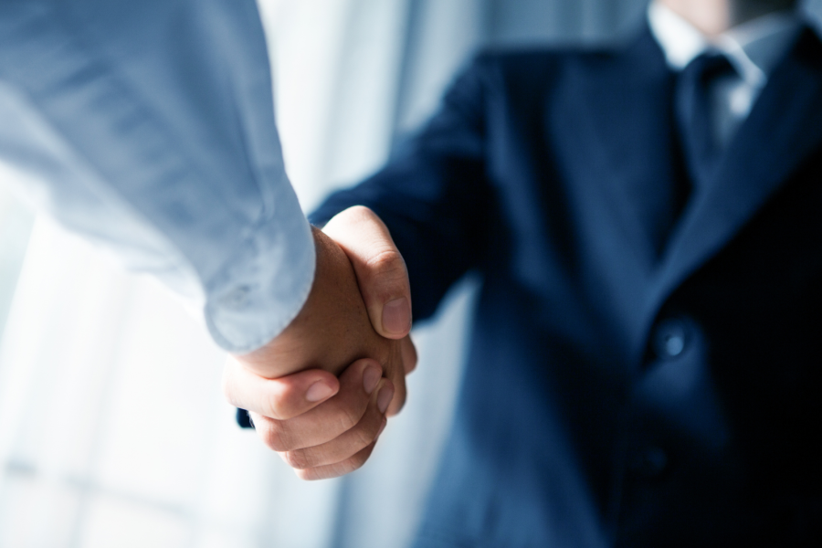 Zwei Männer in Business Kleidung schütteln sich die Hände Vertrauensdienste Trust Services